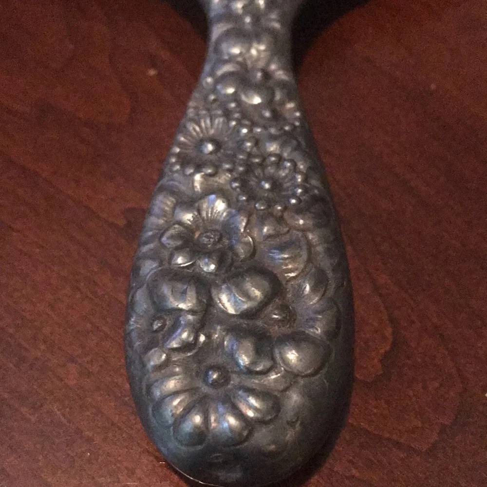 Vintage silver hand held mirror with raised flowers